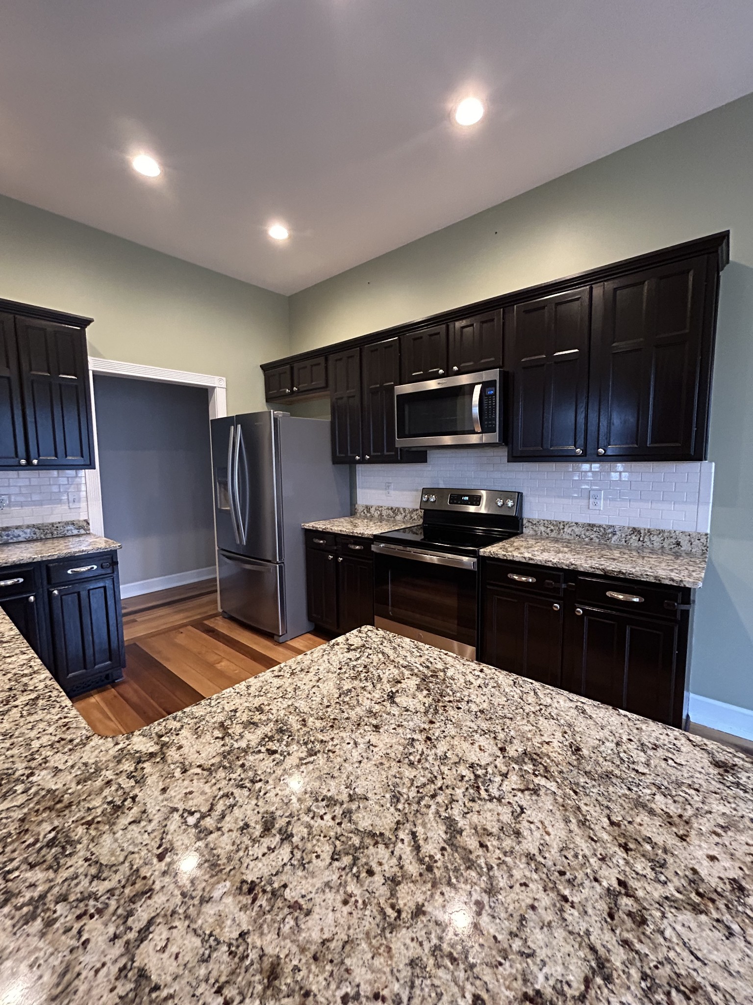 834 Blakemore Road Dickson, TN 37055 - Photo 12 of 26 a kitchen with granite countertop wooden cabinets a refrigerator and a sink