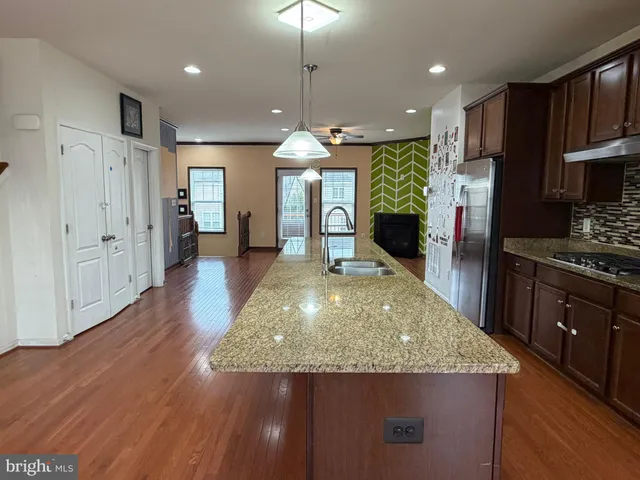 an open kitchen with kitchen island and stainless steel appliances