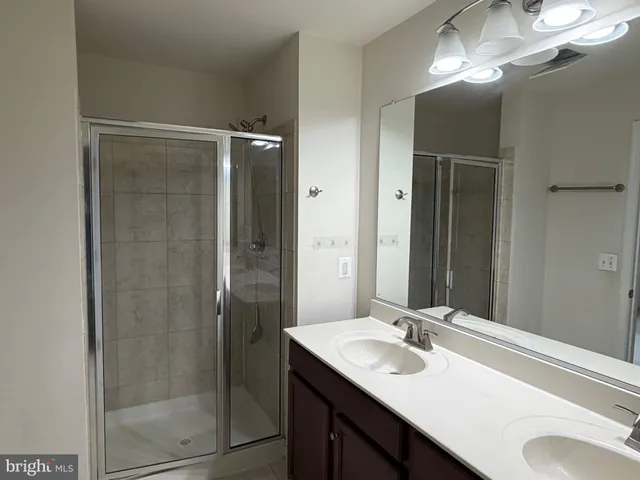 a bathroom with a sink vanity granite shower and a mirror