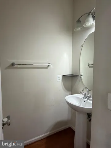 a bathroom with a sink a light fixture and a mirror