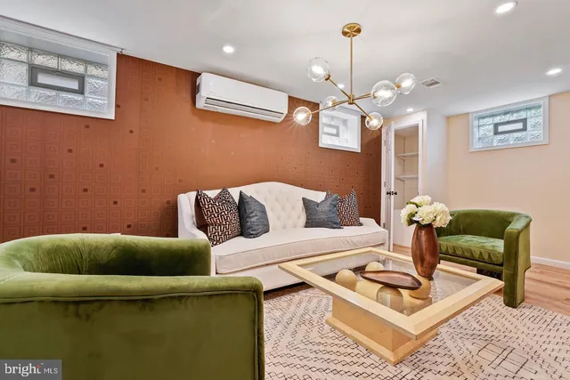 a living room with furniture a chandelier and a rug