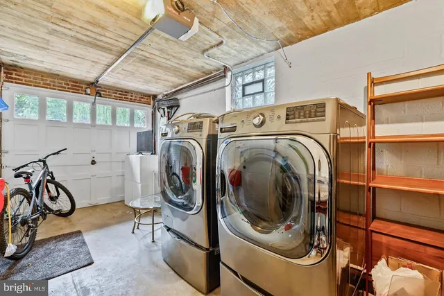 a utility room with dryer washer and a view of living room