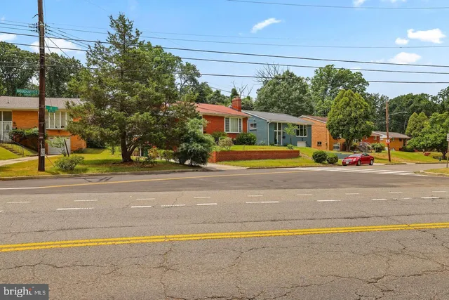 a sign board with a house in the background