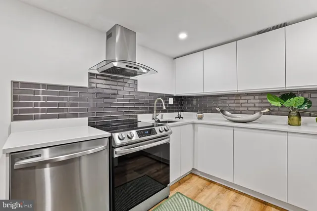 a kitchen with stove cabinets and stainless steel appliances