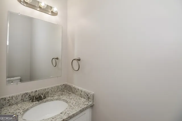 a bathroom with a granite countertop sink and mirror