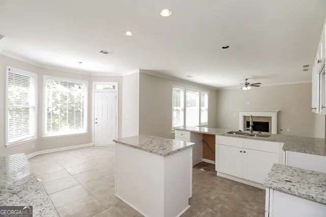 a spacious bathroom with a granite countertop sink and a mirror