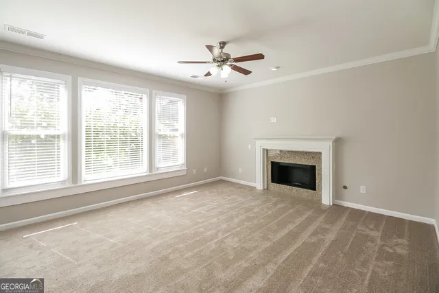 a view of an empty room with a fireplace and a window