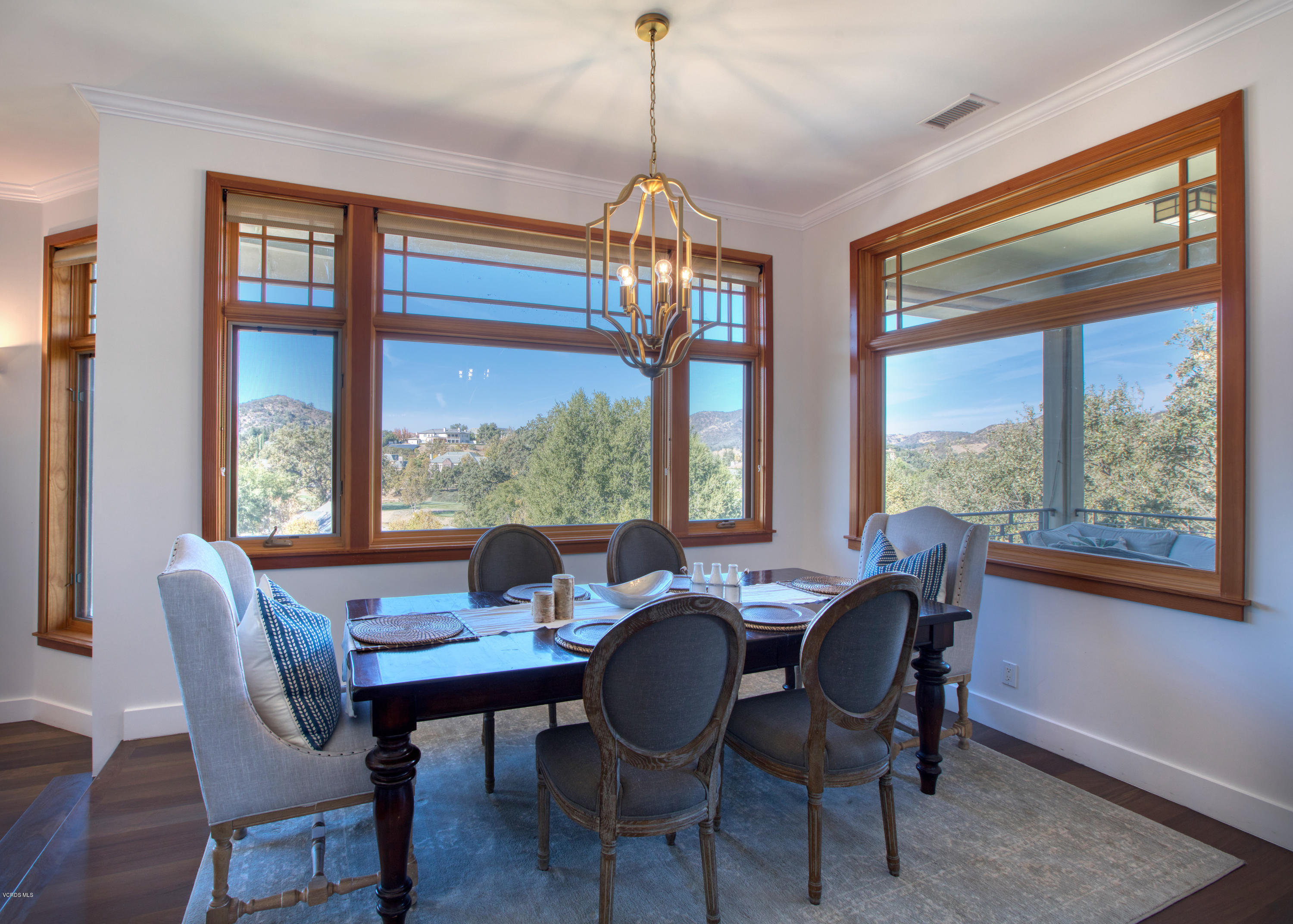 55 Upper Lake Road Westlake Village, CA 91361 - Photo 11 of 40 a dining room with furniture large windows a chandelier and wooden floor