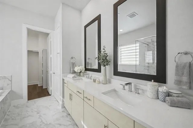 a bathroom with double vanity sinks and a mirror