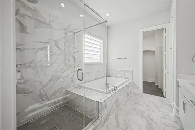 a spacious bathroom with a tub shower and a sink