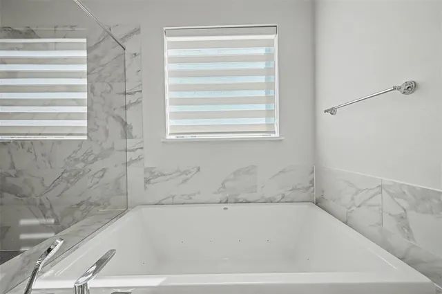 a bathroom with bathtub and window