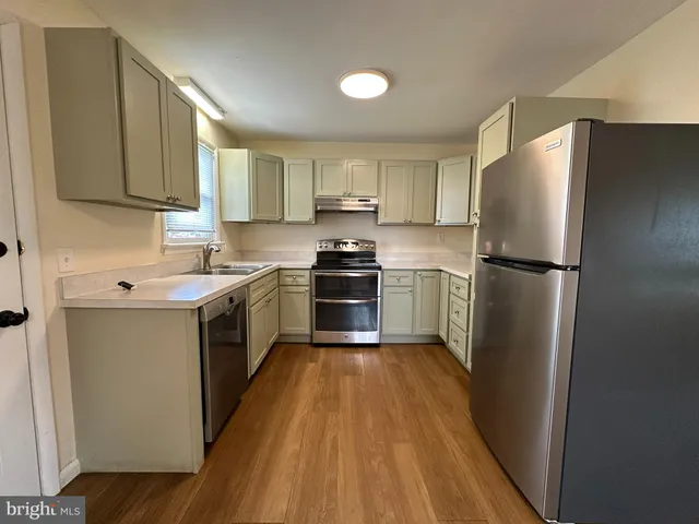 a kitchen with a refrigerator a stove top oven a sink and dishwasher