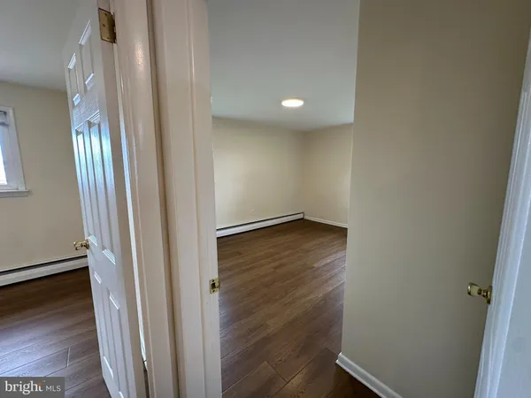 an empty room with wooden floor and entrance