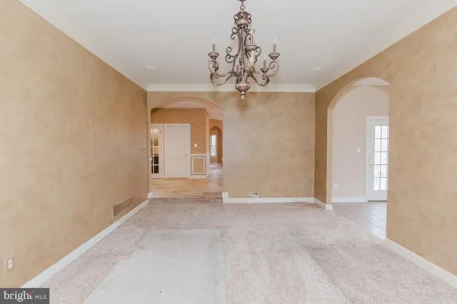 a view of an empty room with wooden floor and a fireplace