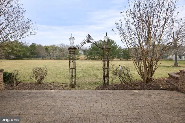 a large kitchen with kitchen island a large counter top a sink a stove and living room view