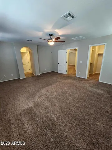 an empty room with a ceiling fan and a window