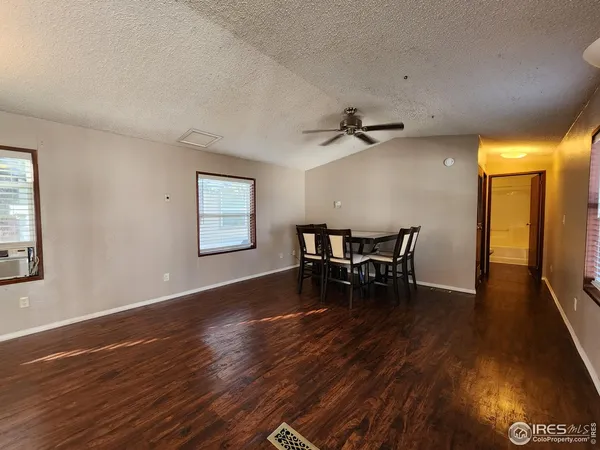 a view of a room with wooden floor and a ceiling fan