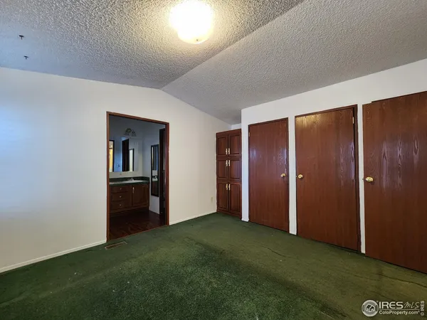 a view of an empty room with closet and wooden floor