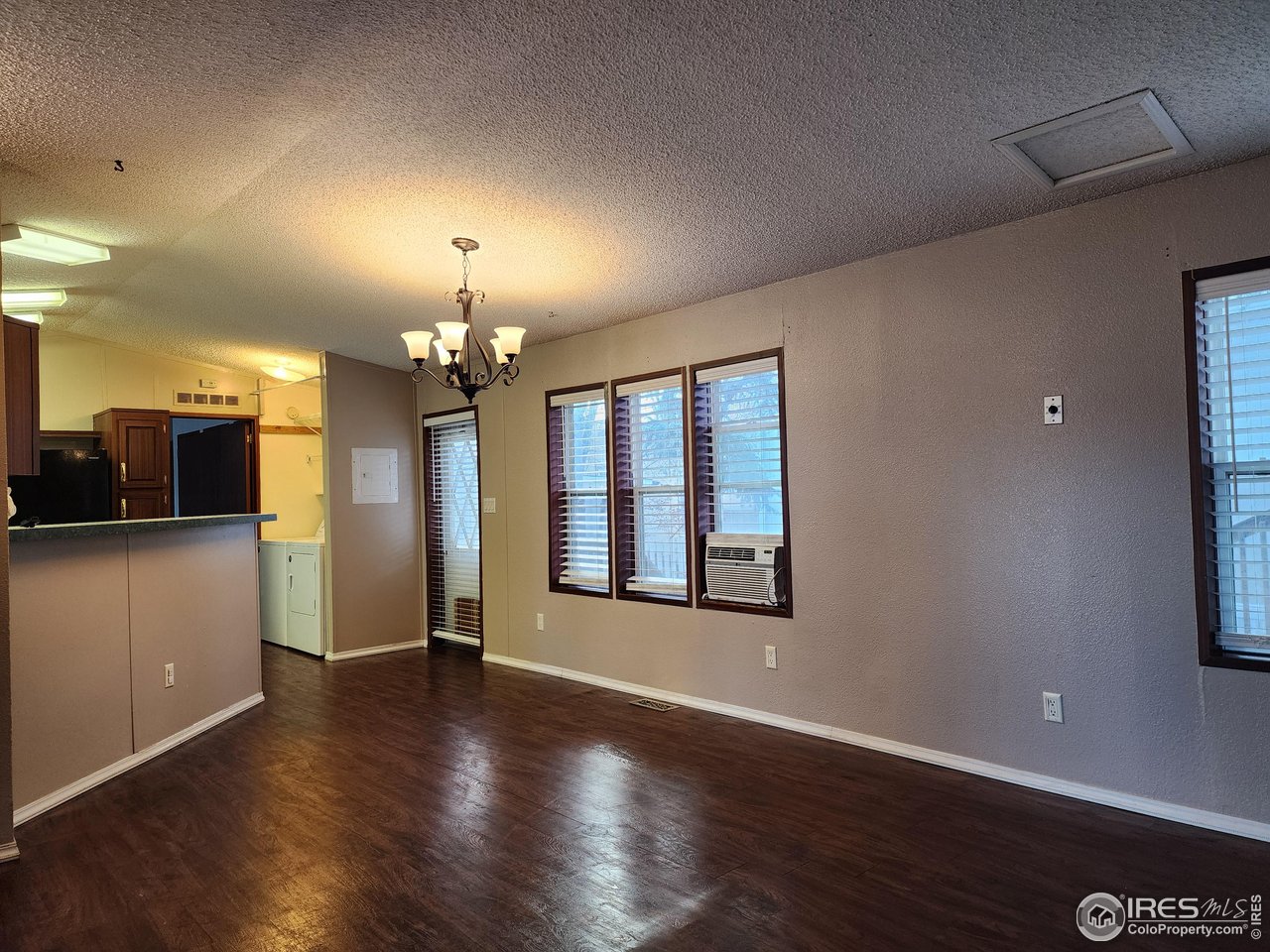 5000 Butte Street, Unit 208 Boulder, CO 80301 - Photo 10 of 37 an empty room with wooden floor chandelier and windows
