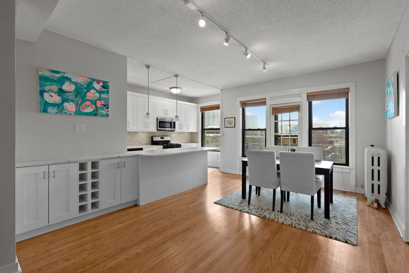 725 West Sheridan Road, Unit 506 Chicago, IL 60613 - Photo 2 of 14 a kitchen with stainless steel appliances granite countertop a stove top oven a sink a dining table and chairs with wooden floor