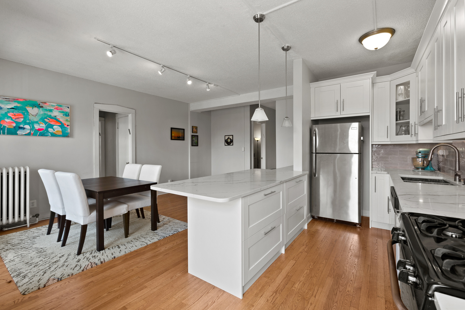 725 West Sheridan Road, Unit 506 Chicago, IL 60613 - Photo 5 of 14 a kitchen with stainless steel appliances granite countertop a table chairs and a refrigerator