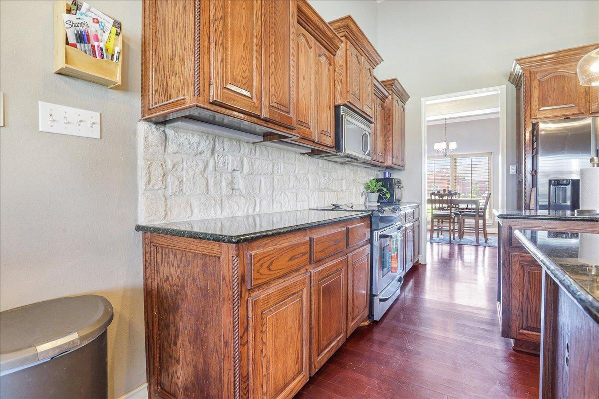 6304 County Road 7475 Lubbock, TX 79424 - Photo 12 of 28 a kitchen with stainless steel appliances granite countertop a refrigerator a sink and wooden cabinets