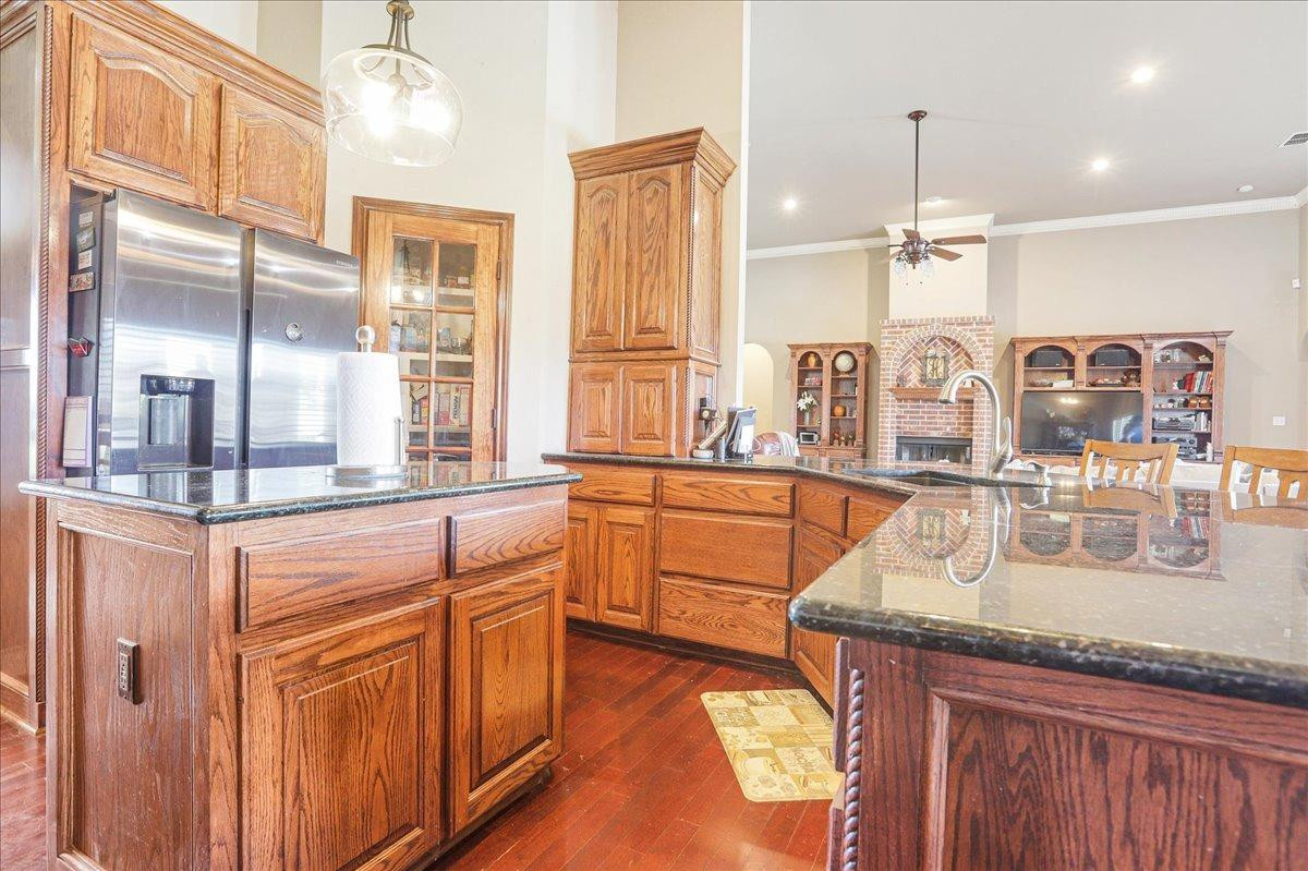 6304 County Road 7475 Lubbock, TX 79424 - Photo 10 of 28 a kitchen with stainless steel appliances granite countertop a sink a stove and a wooden floors