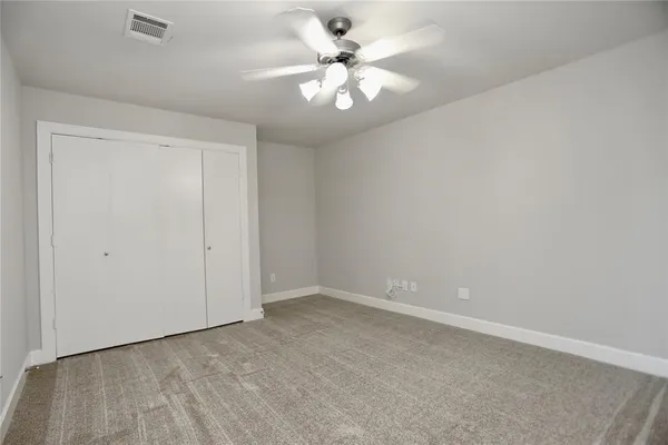 a view of an empty room with a ceiling fan and a window