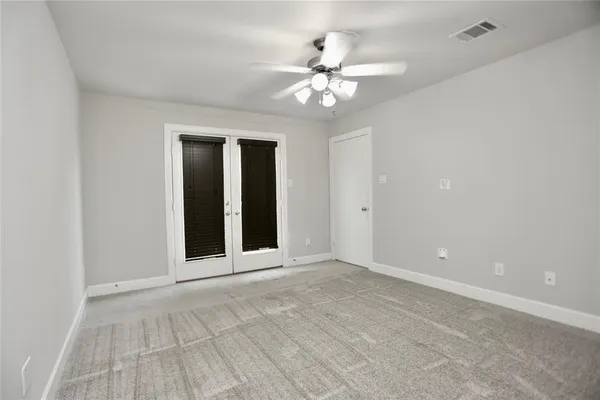 a view of an empty room with a chandelier fan