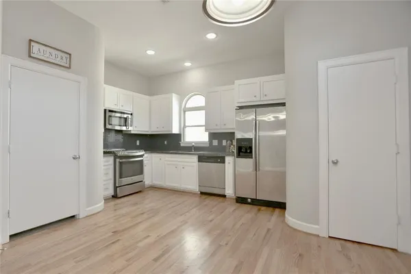 a kitchen with a refrigerator and white cabinets