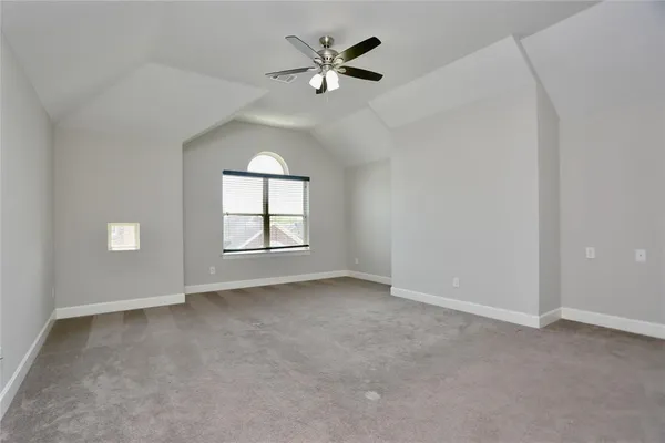 an empty room with windows and ceiling fan