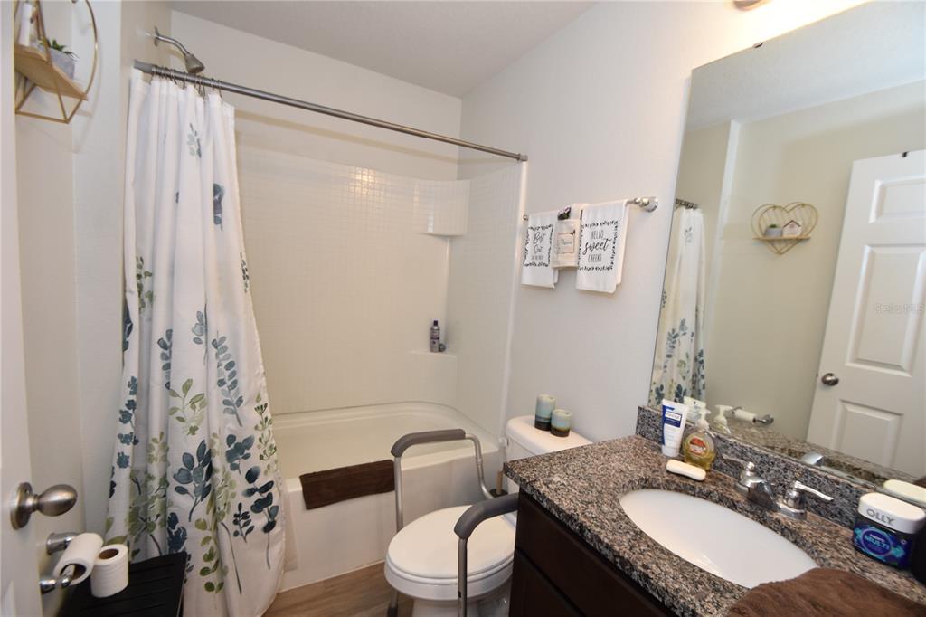 5 Rainstone Lane Palm Coast, FL 32164 - Photo 12 of 33 a bathroom with a granite countertop sink toilet a mirror a vanity and shower