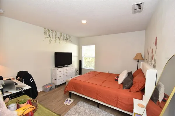 a bedroom with a bed and a flat screen tv