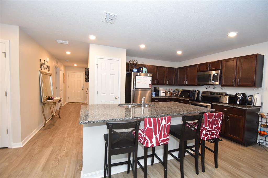 5 Rainstone Lane Palm Coast, FL 32164 - Photo 21 of 33 a kitchen with a dining table chairs and refrigerator