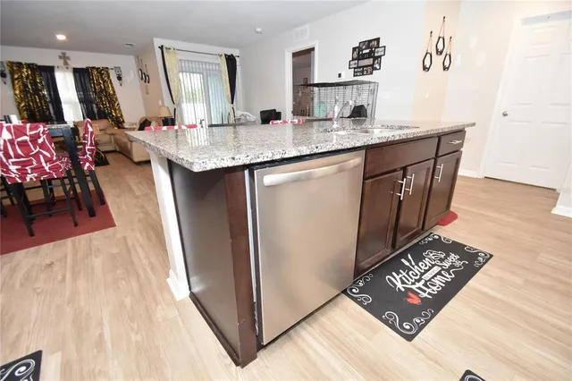 a living room with granite countertop furniture a rug a flat screen tv and a table