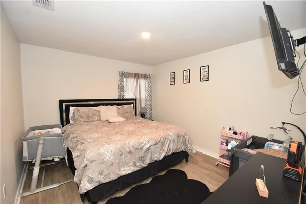 a bedroom with a bed and wooden floor