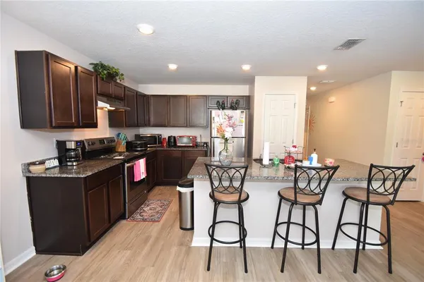 a kitchen with stainless steel appliances kitchen island granite countertop a sink and cabinets