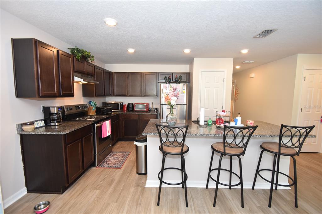 5 Rainstone Lane Palm Coast, FL 32164 - Photo 4 of 33 a kitchen with stainless steel appliances kitchen island granite countertop a sink and cabinets