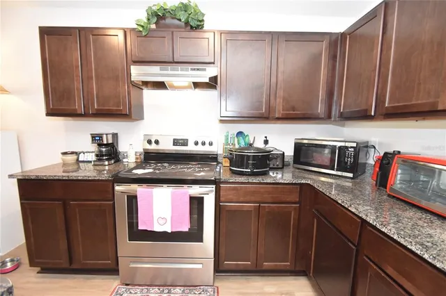 a kitchen with stainless steel appliances granite countertop wooden cabinets a sink and dishwasher