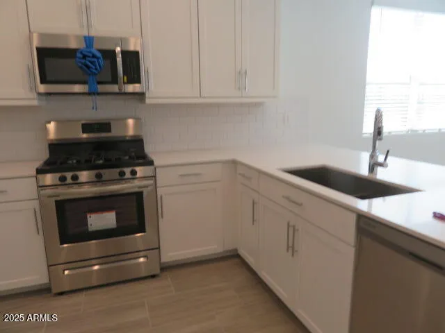 a kitchen with cabinets appliances and a sink