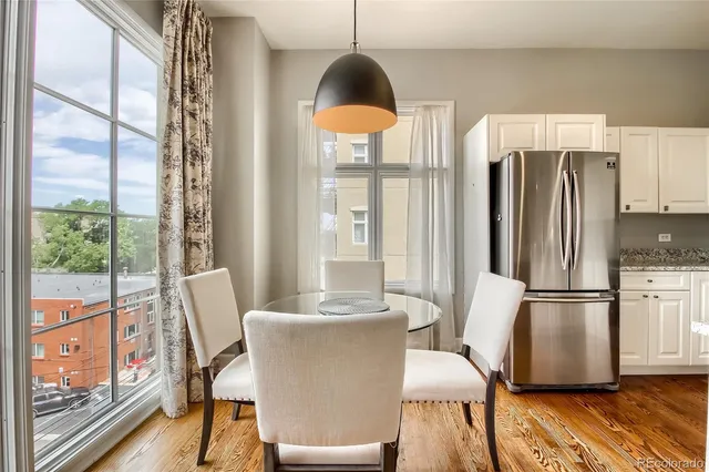 a dining room with furniture a chandelier and wooden floor