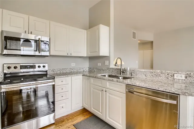 a kitchen with stainless steel appliances granite countertop a stove sink and cabinets