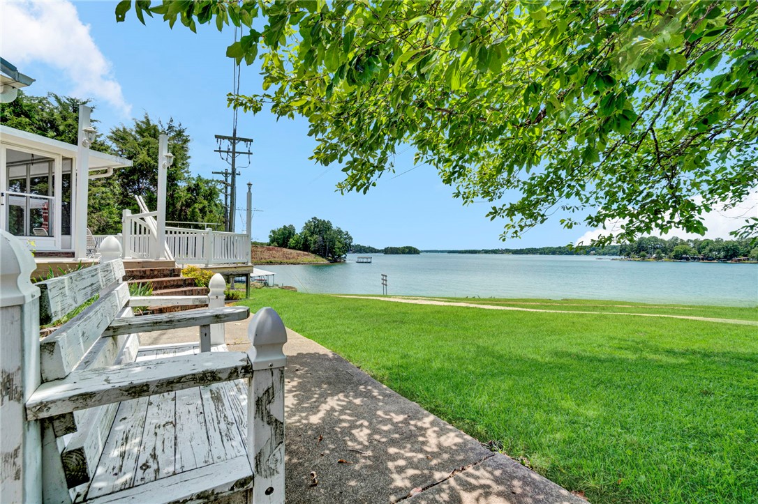 225 Nicholson Cove Road Seneca, SC 29672 - Photo 5 of 22 A captivating lakefront vista unfolds with verdant lawns leading to tranquil waters and distant wooded shores.