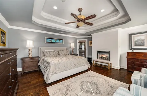 a bedroom with a large bed a chandelier and dresser