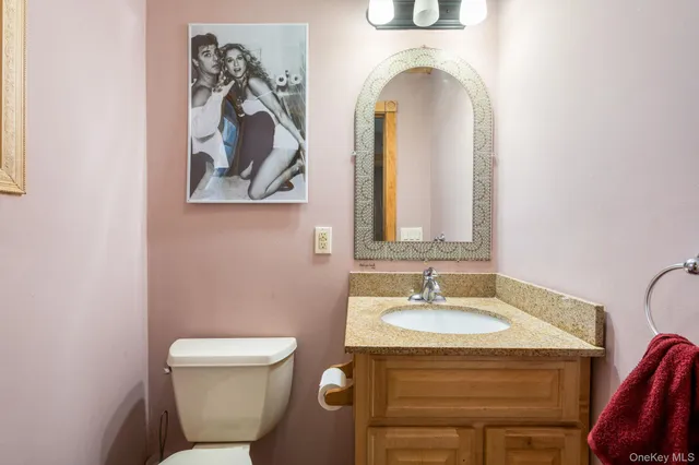 a bathroom with a toilet a sink and mirror