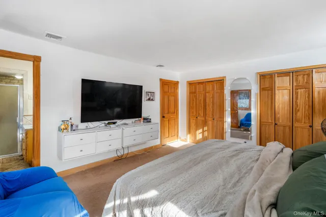 a bedroom with a flat screen television and a bed