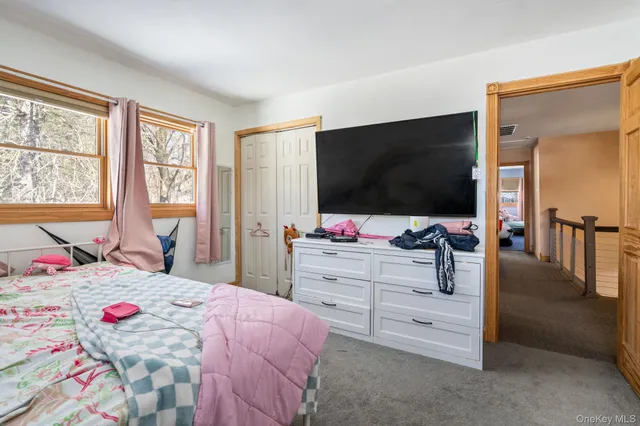 a bedroom with a bed and flat screen tv