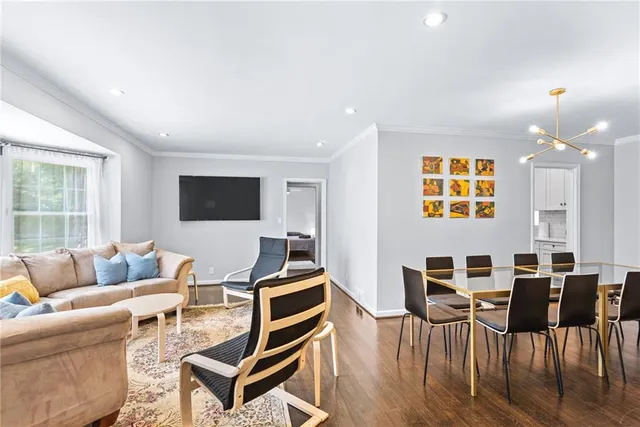 a living room with furniture a flat screen tv and a large window