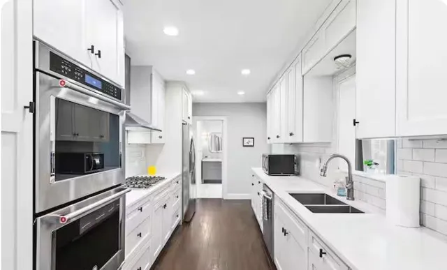 a kitchen with stainless steel appliances sink a microwave and cabinets