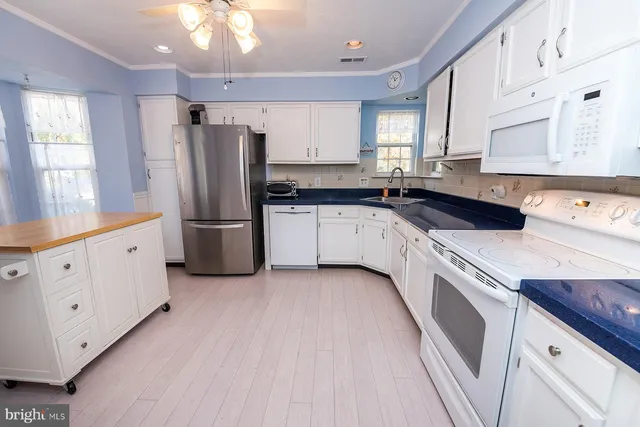 a kitchen with granite countertop a refrigerator and a sink